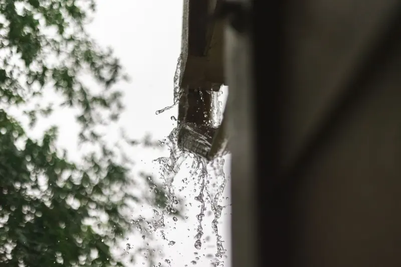 Rainwater spilling over the front edge of an undersized gutter