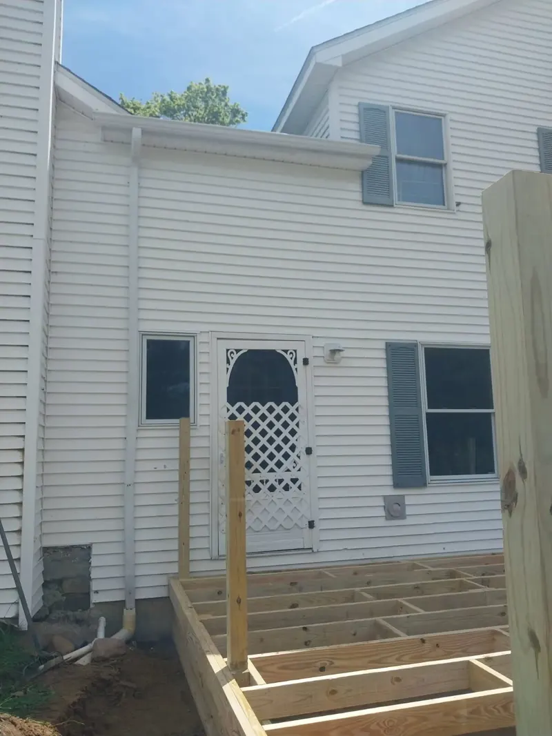 New white seamless gutters and downspout installed on a two-story home near Utica, NY